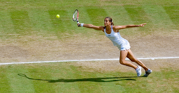 "Mauresmo stretching". Amelie Mauresmo, Ladies' Champion, Ladies' Singles Final, Centre Court, Wimbledon.